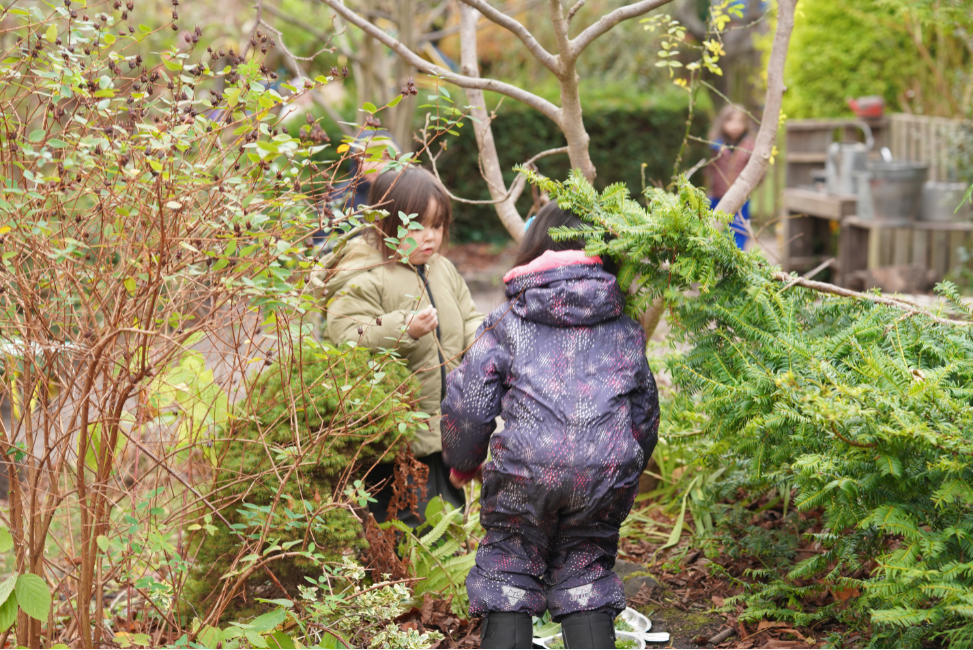 Young children in imaginative play outdoors in nature instead of classroom.